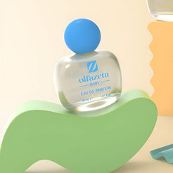 Priehľadný flakón Olfazeta by Chogan Baby N°45, modrý uzáver, položený na pastelovozelenej vlne